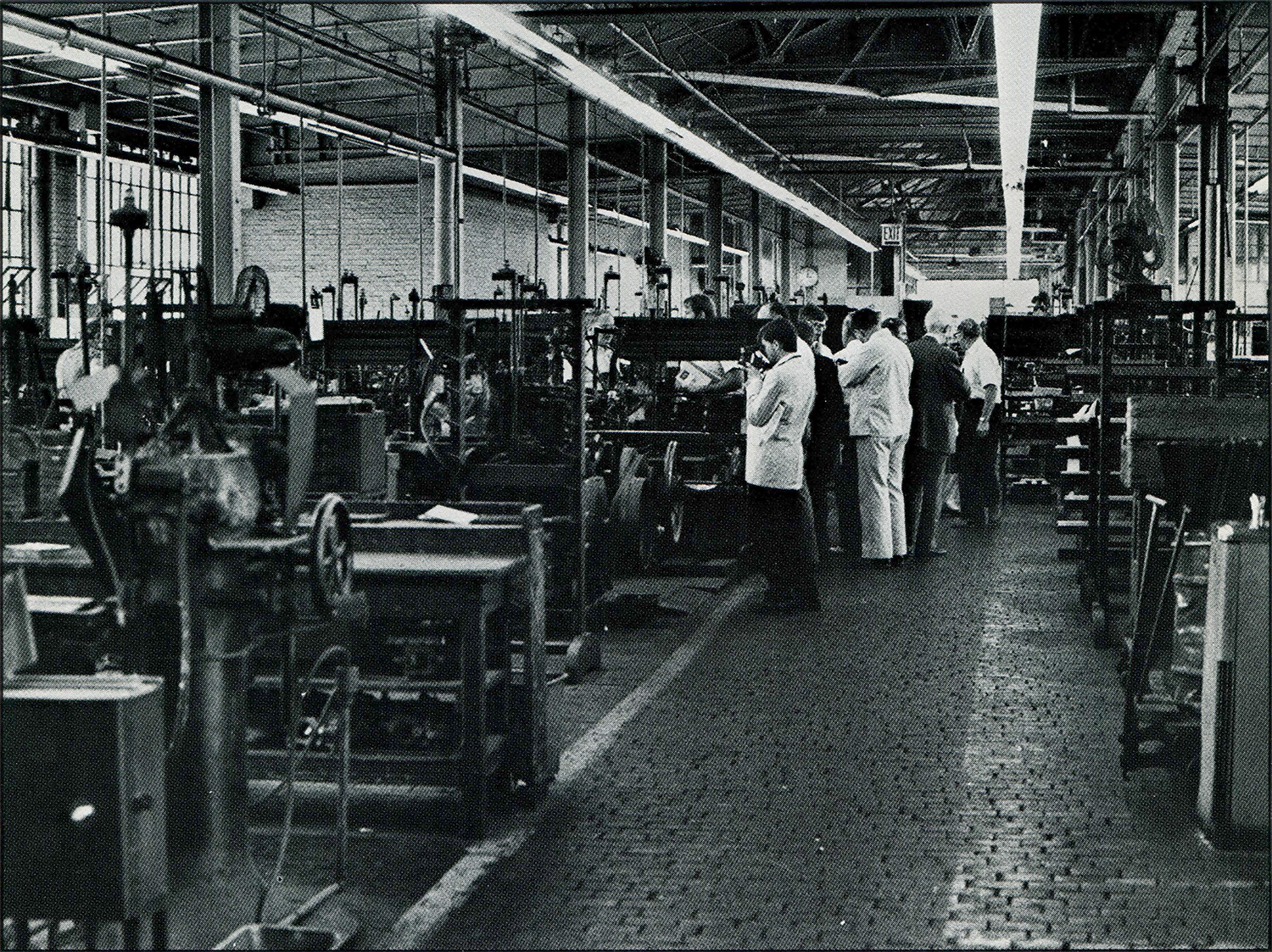 Lathes, drill presses, and milling machines lining an aisle