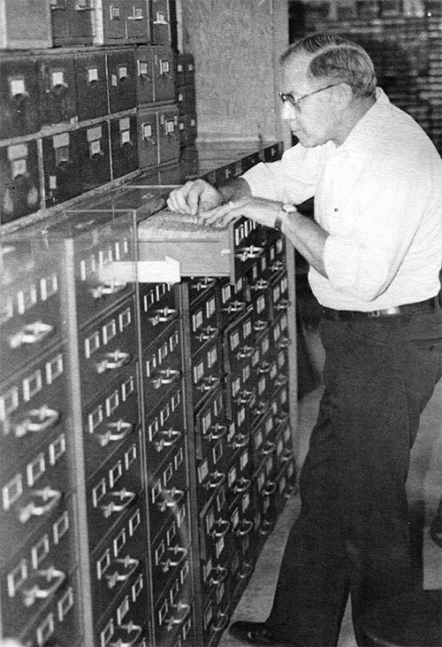 Photograph of Dick Hartzell searching through drawers