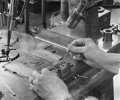 Operator loads blank pucnh for engraving